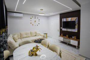 a living room with a table and a couch at Golden Apartment Korce in Korçë