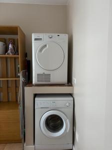a washer and dryer with a microwave on top of it at American Style Vacation Home in Valea Seacă
