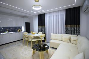 a living room with a white couch and a table at Golden Apartment Korce in Korçë