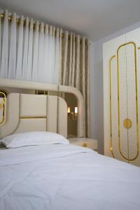 a bedroom with a large white bed and a window at Golden Apartment Korce in Korçë
