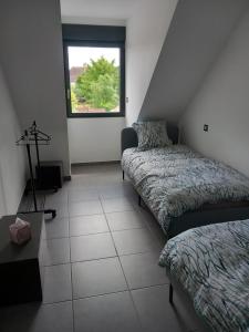 a small room with two beds and a window at Chambres d'hôtes bord de Saône in Lamarche-sur-Saône