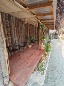 een houten veranda met een tafel en stoelen erop bij Hostel Flakos in Zihuatanejo +25 foto's