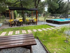 a park with a bench and a swimming pool at La Posada Bungalows in Necochea