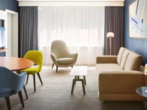 een woonkamer met een bank, stoelen en een tafel bij Sofitel Luxembourg Europe in Luxemburg +110 foto's