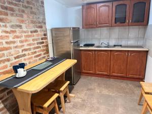 a kitchen with a wooden table and a refrigerator at Silesia młyn in Katowice