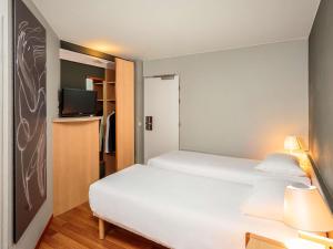 una camera d'albergo con un letto e una tv di Ibis Brussels City Centre a Bruxelles Altre 96 foto