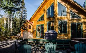 a log cabin with chairs and a grill at Chalets Gallix in Sept-Îles