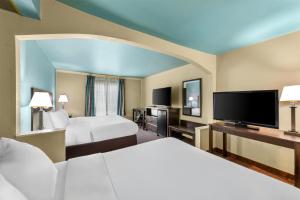 een hotelkamer met twee bedden en een flatscreen-tv bij Red Lion Inn & Suites Blue Springs in Blue Springs