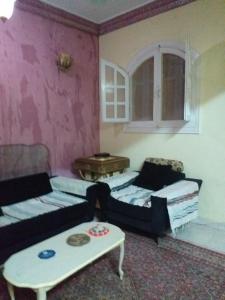 een woonkamer met een bank en een tafel bij Mourad morsy مراد in Najâ€˜ al MadÄbb