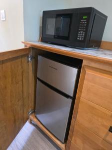 a microwave sitting on a counter next to a refrigerator at Oceanside Getaway in Nanoose Bay