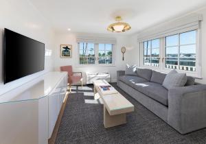 a living room with a couch and a flat screen tv at Bay Shores Peninsula Hotel in Newport Beach