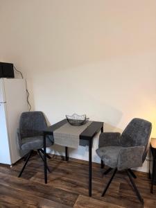 un tavolo nero con due sedie e un tavolo con una ciotola sopra di Apartmán Pardubice 3 a Pardubice