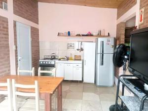 a kitchen with a table and a refrigerator at Cabañas Las Pasionarias in Tanti