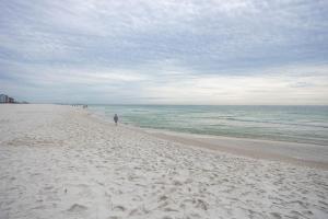 a person walking on a sandy beach next to the ocean at Phoenix X 304 in Orange Beach +44 photos