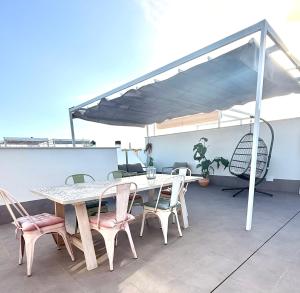a patio with a table and chairs on a roof at Casa Amorosa in San Pedro del Pinatar