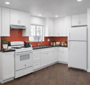 a kitchen with white cabinets and a white refrigerator at The Olympic Suites LA in Los Angeles +30 photos