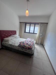 een slaapkamer met een bed in een kamer met een raam bij Depto céntrico p 6 personas in Miramar