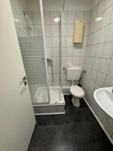 a bathroom with a shower and a toilet and a sink at Duisburg Flats 24 in Duisburg