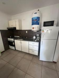 een keuken met een witte koelkast en een waterkan erop bij Depto céntrico p 6 personas in Miramar