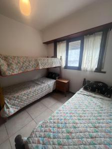 een slaapkamer met twee bedden en een raam bij Depto céntrico p 6 personas in Miramar