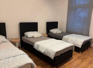 a room with three beds and a window at Duisburg Flats 24 in Duisburg +3 photos