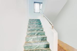 eine Treppe in einem Haus mit grünen und weißen Wänden in der Unterkunft Hotel O Happy Stay in Méribel Village + 47 Fotos