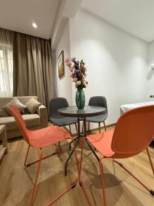ein Wohnzimmer mit einem Tisch mit Stühlen und einer Vase aus Blumen in der Unterkunft Studio la capitale in Rabat