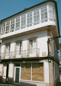 an apartment building with a balcony on a street at A galería do san Ramón in Villalba