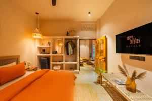 a bedroom with an orange bed and a tv at ONEOFF X ASSI - A Boutique Homeotel in Varanasi