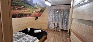 a small room with a bed and a window at Przy Potocku in Czarna Góra