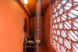 a bathroom with orange walls and a window at ONEOFF X ASSI - A Boutique Homeotel in Varanasi +34 photos