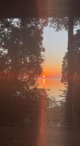 een zonsondergang boven een waterlichaam met bomen bij The Hill Koh Mak 