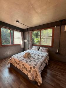 een slaapkamer met een bed in een kamer met ramen bij The Hill Koh Mak 