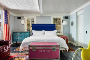 una camera da letto con un letto con testiera blu e un baule rosso di Hotel Saint Cecilia ad Austin