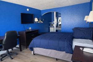 een blauwe slaapkamer met een bed en een bureau met een computer bij Apollo Lodge and RV Park in Fairfield