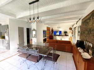 a dining room and living room with a glass table and chairs at La 1848 Narbonnaise in Narbonne