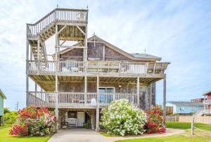 a large wooden house with balconies and flowers at This is it - Nags Head MP 16, Ocean View, 75 Yards to Beach, Elevator, Wheelchair Friendly, Flex Stays in Nags Head