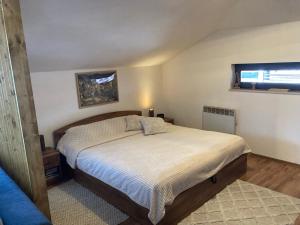 een slaapkamer met een bed en een raam bij Студио за гости Петрови in Bansko
