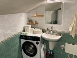 een badkamer met een wasmachine en een wastafel bij Студио за гости Петрови in Bansko +94 foto's