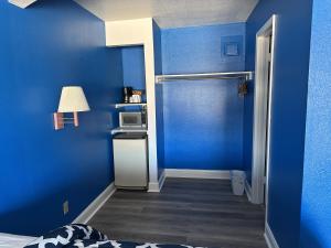 een blauwe kamer met een bed en een magnetron bij Apollo Lodge and RV Park in Fairfield