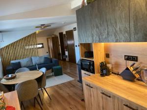 ein Wohnzimmer mit einem blauen Sofa und einem Tisch in der Unterkunft Студио за гости Петрови in Bansko