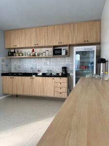 een keuken met houten kasten en een aanrechtblad bij Muira Stay Belém Hostel in Belém +31 foto's