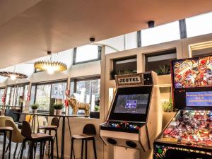 een kamer met twee videospelletjes en twee speelautomaten bij ibis Paris Bercy Village in Parijs
