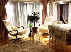 a living room with a table and chairs and a plant at Unikt sommarboende in Färjestaden