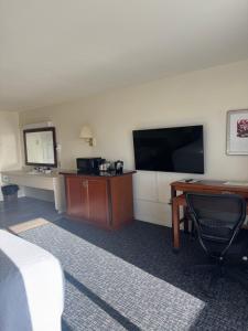 a hotel room with a desk and a flat screen tv at Bayview Inn in Crescent City