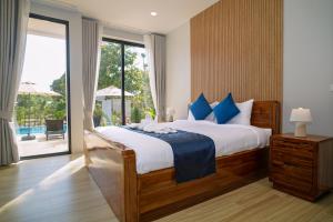 een slaapkamer met een groot bed met blauwe kussens bij Sinapa Suites in Ko Pha Ngan