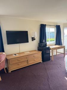 a living room with a flat screen tv and a table at Bayview Inn in Crescent City