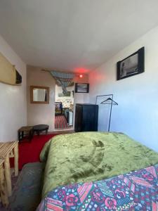 une chambre avec un lit et un salon dans l'établissement Studio Surf House Kaouki, à Sidi Kaouki