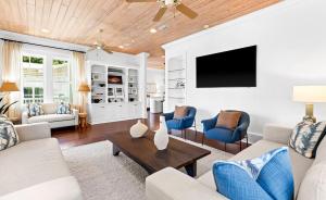 a living room with white furniture and a flat screen tv at Seagrove Sun in Santa Rosa Beach