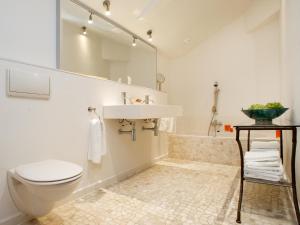 a bathroom with a toilet and a sink and a tub at Hövell in Huizen